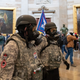 Supporters of US President Donald Trump wear gas masks and military-style apparel as they walk around inside the Rotunda after breaching the US Capitol in Washington, DC, January 6, 2021. - Demonstrators breeched security and entered the Capitol as Congress debated the 2020 presidential election Electoral Vote Certification.